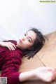 A woman laying on the floor in a red and black dress.