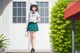 A girl in a school uniform standing in front of a building.