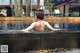 A woman in a pink bikini sitting in a swimming pool.