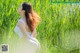 A woman in a white dress standing in tall grass.