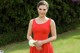 A woman in a red dress holding a bouquet of flowers.